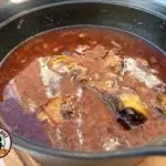 Coq au vin in Dutch oven op de BBQ, close-up eindresultaat